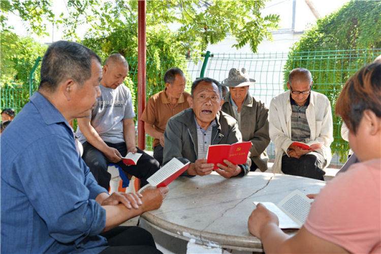 　　河北深州市魏家橋鎮(zhèn)孟家村老黨員孟凡濤（中）在“胡同黨?！崩首x黨章（2016年6月15日攝）。 新華社記者 牟宇 攝